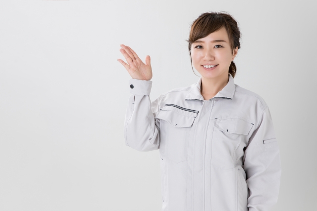 案内する作業着の女性スタッフ
