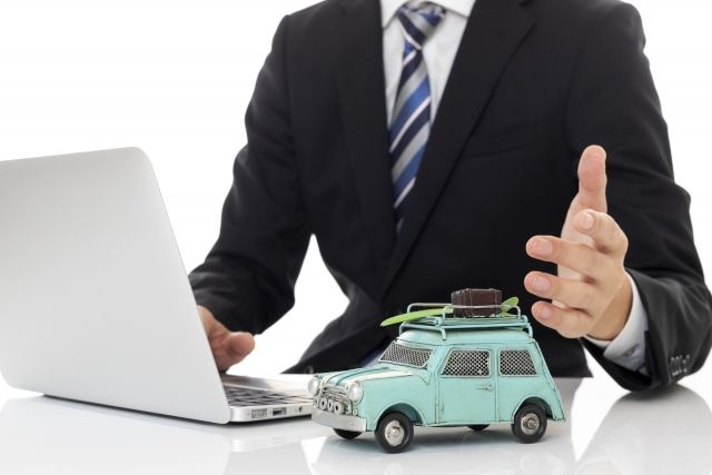 車のおもちゃと説明する男性